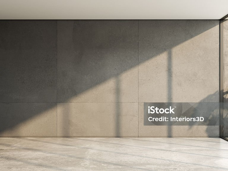 Leerer Raum mit großformatigen Wandplatten und durchgehendem Steinboden